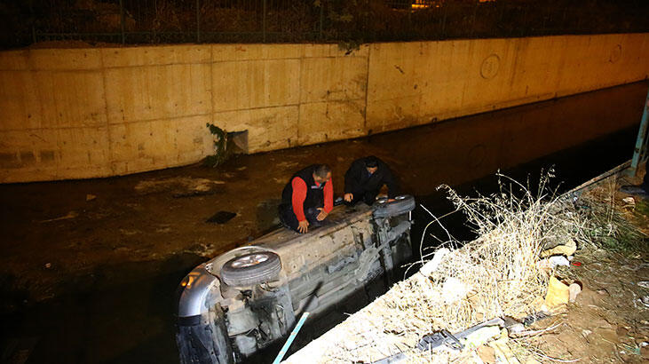 Dereye düşen aracın üstünde kurtarılmayı beklediler