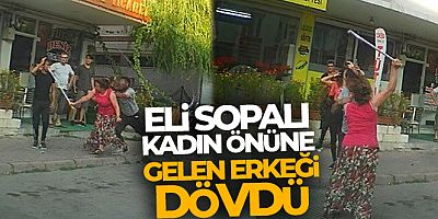 Eli sopalı kadın önüne gelen erkeği dövdü