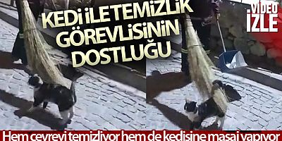 Hem çevreyi temizliyor hem de sokak kedisine süpürgesi ile masaj yapıyor
