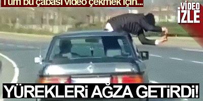 Video çekmek için trafikte arabadan sarkan şahıs yürekleri ağıza getirdi